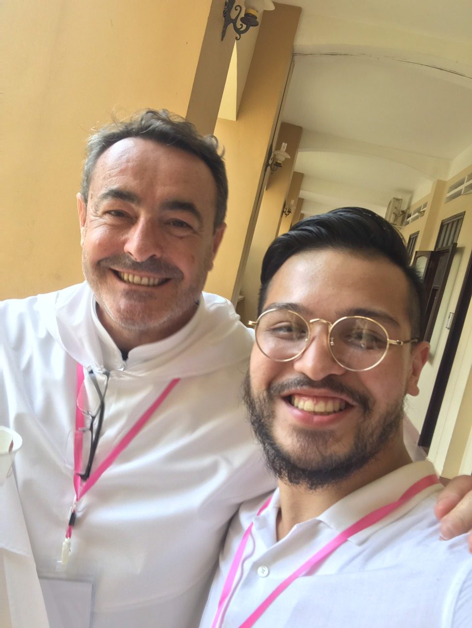 Selfie of Benz Rodil with a smiling Dominican friar in a white habit in an arcaded corridor
